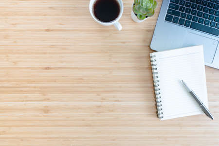 flat lay composition with notebook, pen, coffee, plant, laptop on wood background. Conceptの写真素材