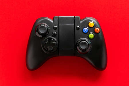 Black game Joystick isolated on a red backgroundの写真素材