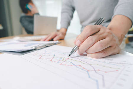 Hand of businessman point to graph. is discussing together in conference room talk about Report,...