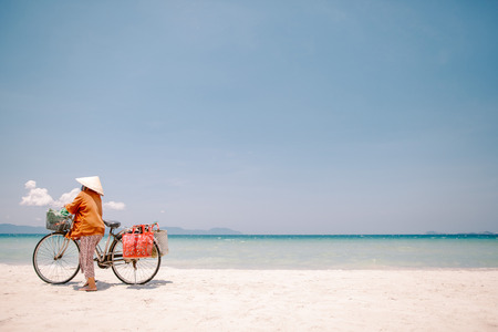 Beach seller in a hat with a bicycleの写真素材
