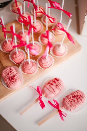 Round, raspberry keypops on a wooden trayの写真素材