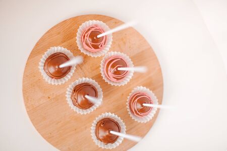 Round chocolate keikpops on a wooden tray.の写真素材