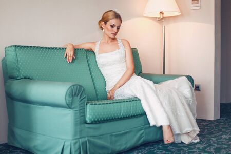 Model bride posing in a hotel on the couchの写真素材