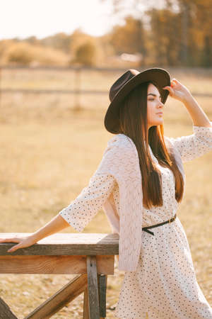 Young girl in dress and hat posing on the farmの写真素材