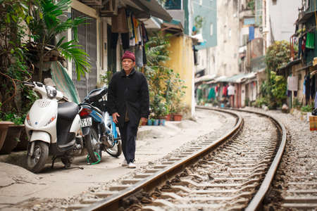 Hanoi, Vietnam, January 13, 2018: A Vietnamese man walks along the railroad along the houses in the center of Hanoiのeditorial素材