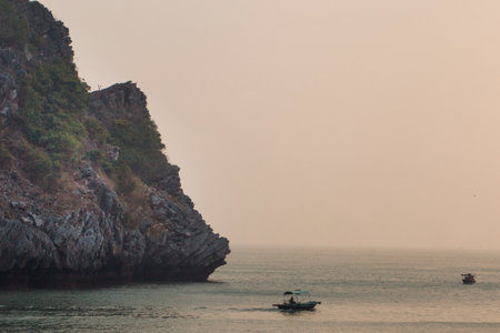 Sunset view on rock islands with fishing boat in Ha Long Bay near to Cat Ba, Vietnam.の写真素材