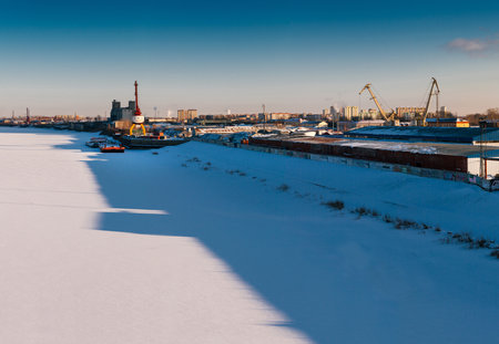 Industrial landscape with port cranes in docks. River port in winter.の写真素材