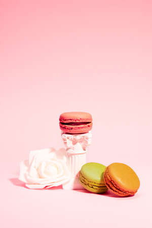 French colorful pastel macarons on pink background. Pink raspberry, green pistachio and brown coffee flavour. Beautiful and romantic dessert. Perfect for Valentines Day.の写真素材