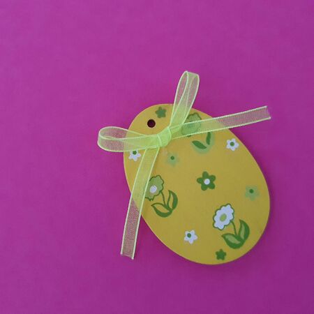Wooden yellow egg decoration. Easter. Purple background. Top view, copy spaceの写真素材