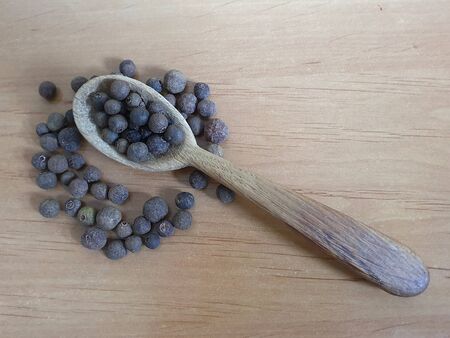 Pepper on wooden background and wooden spoon, copy spaceの写真素材