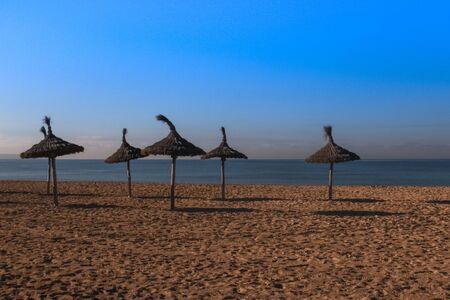Bamboo beach umbrellason the sea sand. Majorca, Spain, Balearic Islandsの写真素材