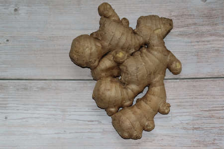 One ripe spicy ginger root isolated on a light rustic background. Concept of healthy foodの写真素材