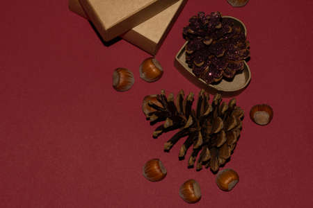 Pattern made of pine cones, nuts on red background. Flat lay, top view, copy spaceの写真素材