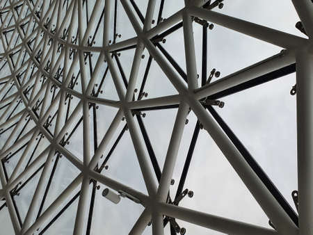 Steel structure geometry construction as the background. Structural glass facade curving roof, abstract architecture fragment copy spaceの写真素材
