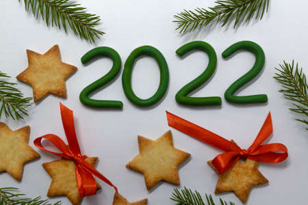 Gingerbread cookies and fir tree branches on white background. Christmas baking background. New Year...
