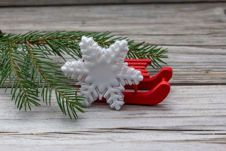 sugar paste snowflakes, fir tree branche, red decorative sleds decoration on a wooden rustic...