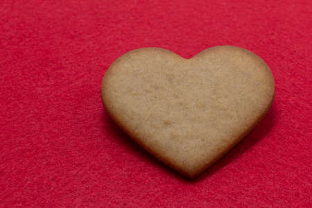 heart shaped homemade gingerbread red felt background, Valentine Day, greeting card, pastry, copy...