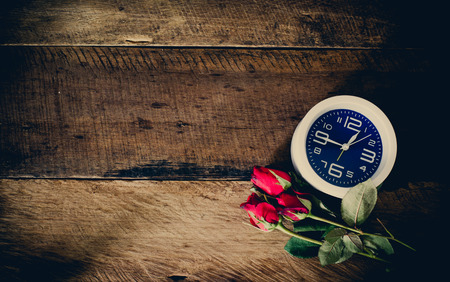 rose  and  alarm clock  on wooden backgroundの写真素材