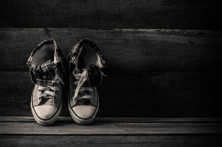 Sneakers on floor on wooden background,the black-whiteの写真素材