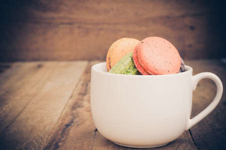 colorful macarons on a wooden floorの写真素材