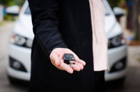 Businesswoman gives the car keys on palmの写真素材