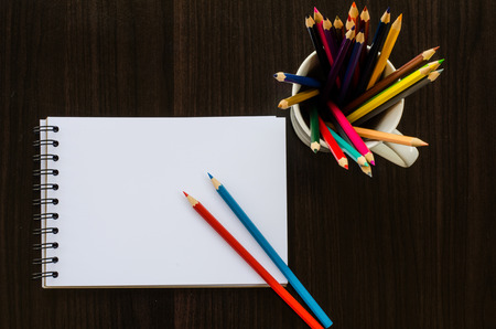 Color pencil and sketchbook on wood tableの写真素材