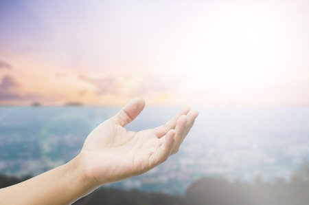 open hand on blurred abstract nature backgroundの写真素材