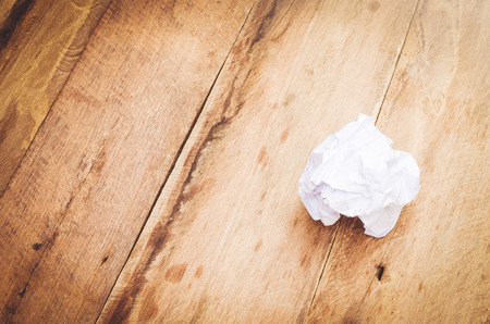 crumpled paper ball on wooden backgroundの写真素材