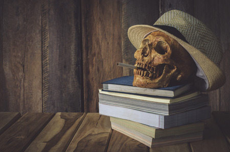 Still life skull . Cap machine weave and books on wooden backgroundの写真素材