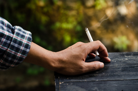 Smoking in the hands of menの写真素材