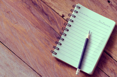 blank notebook with pencil on wooden table - still life