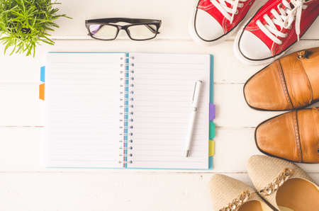 Notebook, pen, shoes, on white wooden floor.の写真素材