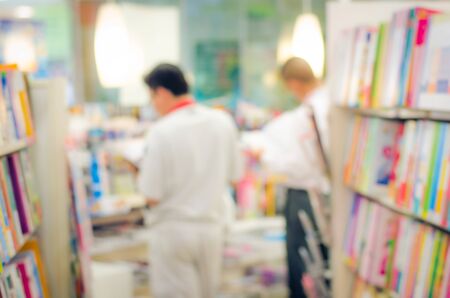 focused/Blur image of a bookstore with customers reading and looking for books. Bookstore background.の写真素材