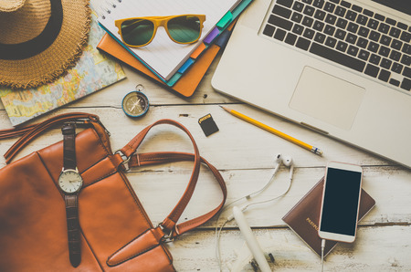 Laptop and travel accessories costumes Tourism planning and equipment needed for the trip on wooden...