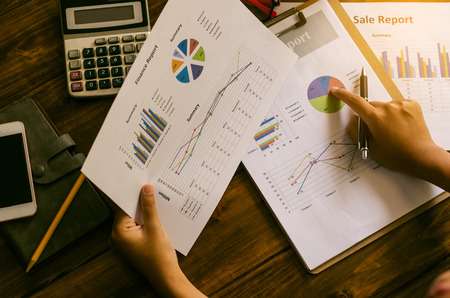 Businessman holding paperwork on the table and analyzing investment chart working in office. Business work concept.の写真素材