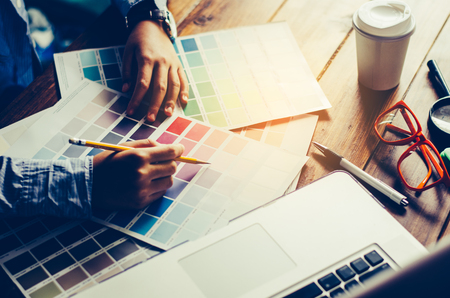 Graphic designer architects who work with laptops and color comparison tables for design work.の写真素材