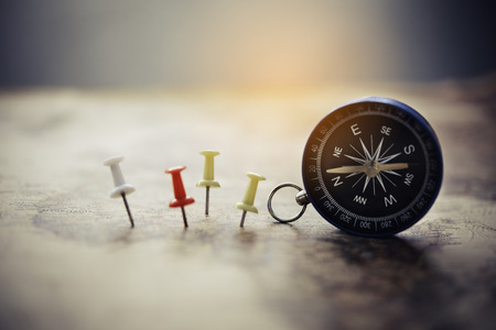 Magnetic compass and embroidery needle is on the map. on a world map conceptual of global travelの写真素材