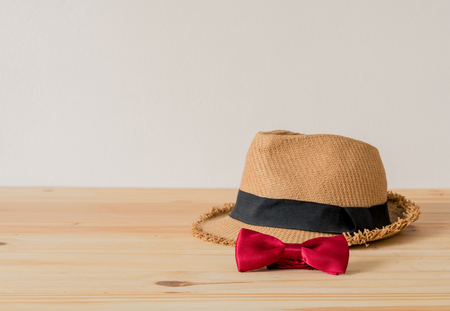 Hat and red bowtie are placed on wooden floor.の写真素材