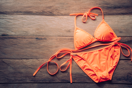 orange bikini rests on a wooden floor -summer and travel cocept.の写真素材