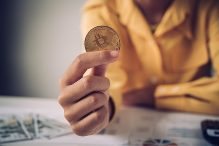 Hand of a businessman holding a gold bitcoinの写真素材