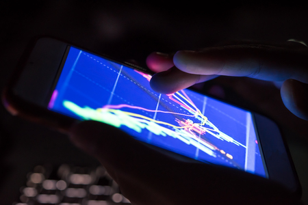 businessman checking stock charts on a mobile device.の写真素材