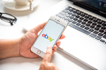LAMPHUN, THAILAND - July 8, 2018: In a hand for man with social networking service Ebay app on a Apple iPhone 6 screen. Ebay is one of the largest online auction and shopping websites.のeditorial素材