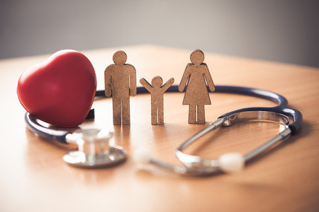 Medical Insurance Concept With Family  And Stethoscope On Wooden Deskの写真素材