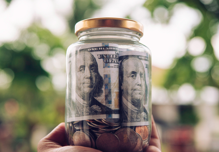 Hand  holding jar in coins  saving money,  finance and investment Concept