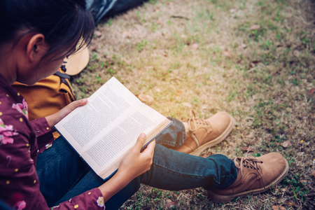 Teenagers are relaxing by reading books in tent picnic area in the garden.の写真素材