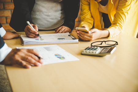 The team is working on accounting documents and team work together to present the work and help solve the problem.の写真素材