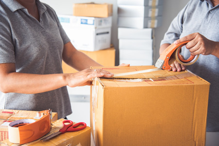Team staff packed in brown boxes to deliver to customersの写真素材