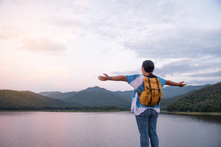 The tourists have a backpack sitting in the sunset in the midst of nature.の写真素材