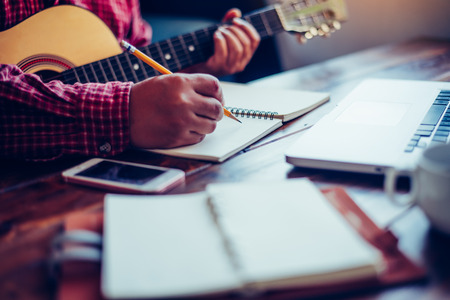 Composers are writing songs on the table with guitars.の写真素材