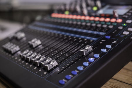 The DJ is adjusting the volume of the sound. Professional audio mixing consoleの写真素材